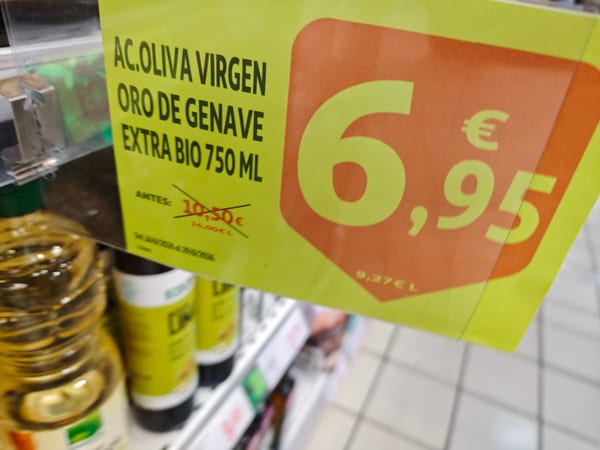 Botella de aceite de oliva virgen extra ecológico sobre fondo oscuro con aceitunas