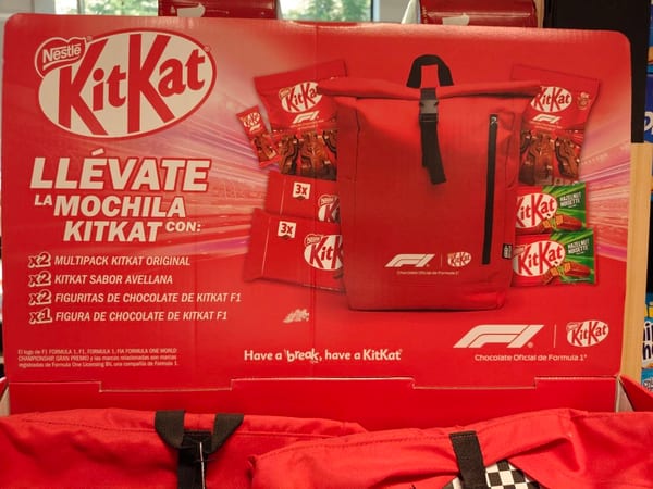 Tableta de chocolate KitKat partida en barritas sobre fondo rojo